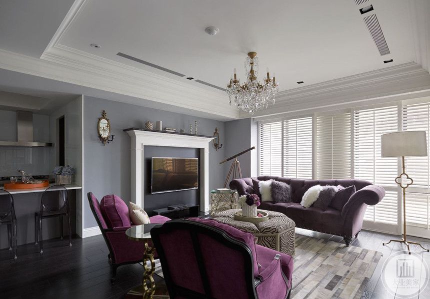 客厅选用柔和安静的灰紫色调，通过不同的材质、色泽、肌理来体现空间的层次感。选用小型影视设备和挂钟，整体简约舒适。
