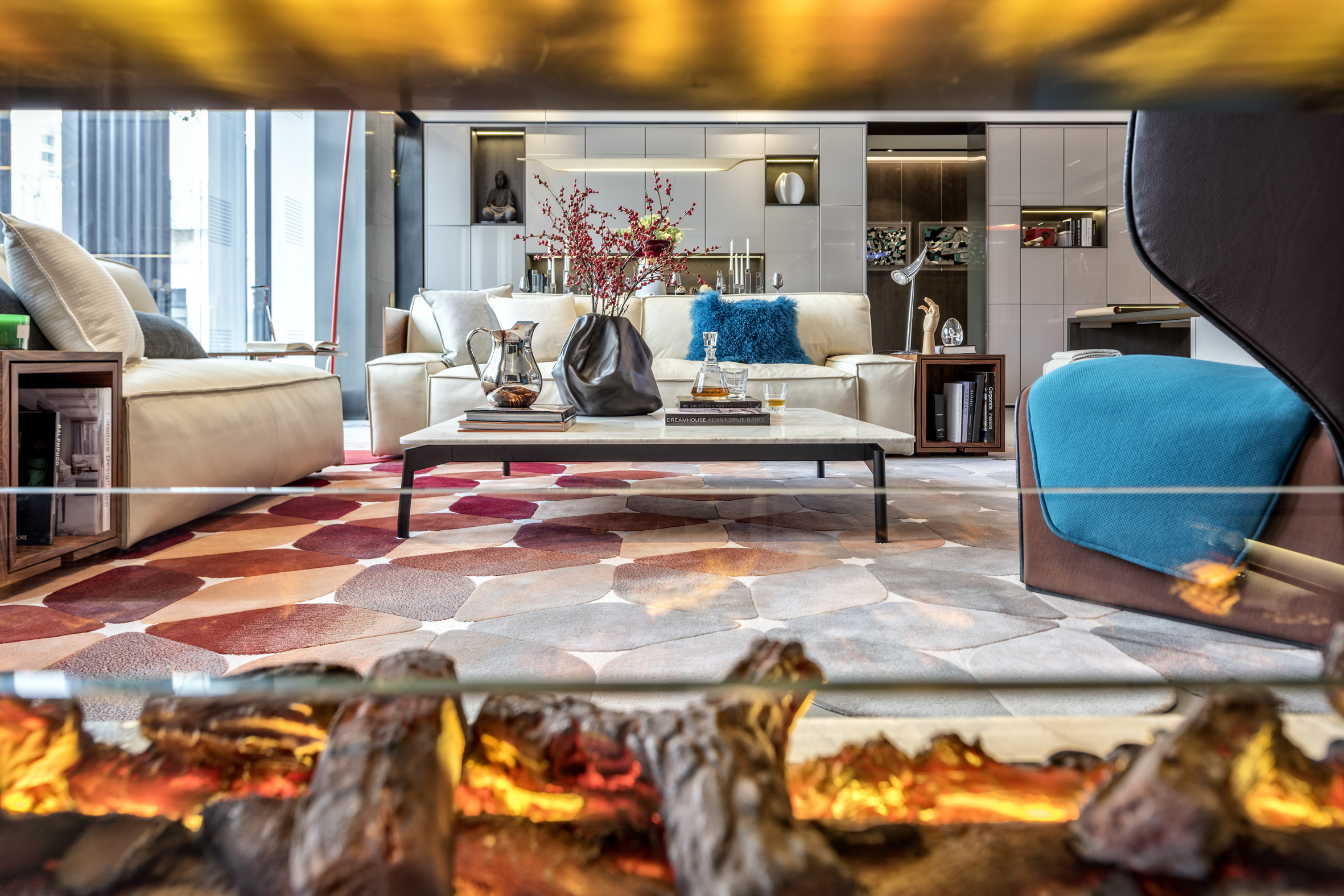 本案客厅和餐厅在一个空间， 客厅的部分相较于传统客厅更为自由随性，设计师选用红色的落地灯配合地毯的色彩。