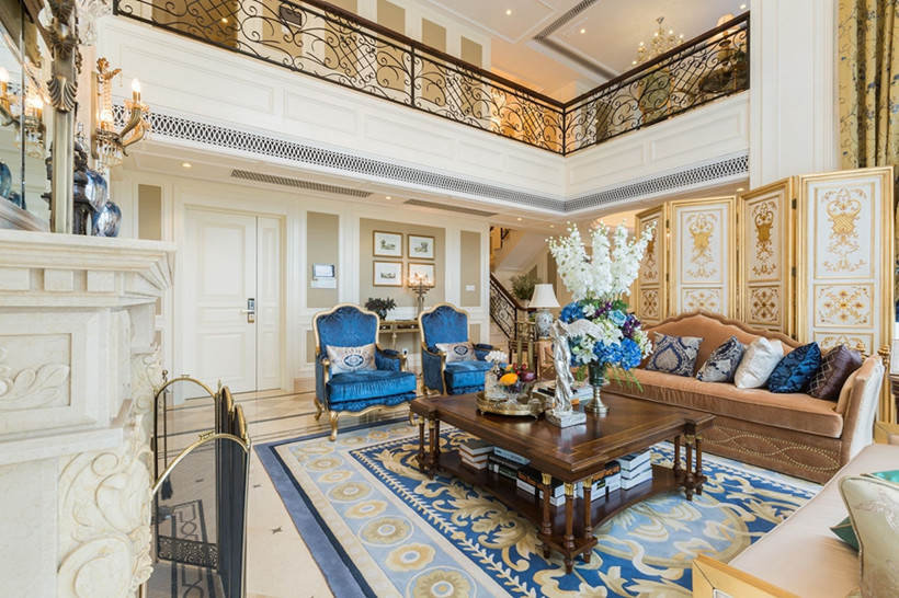 客厅选用蓝色椅子、地垫、花卉装点整体空间，使得整个客厅高雅迷人，屏风和二楼的雕花栏杆给人一种奢华雅致之感，整体氛围浓郁。